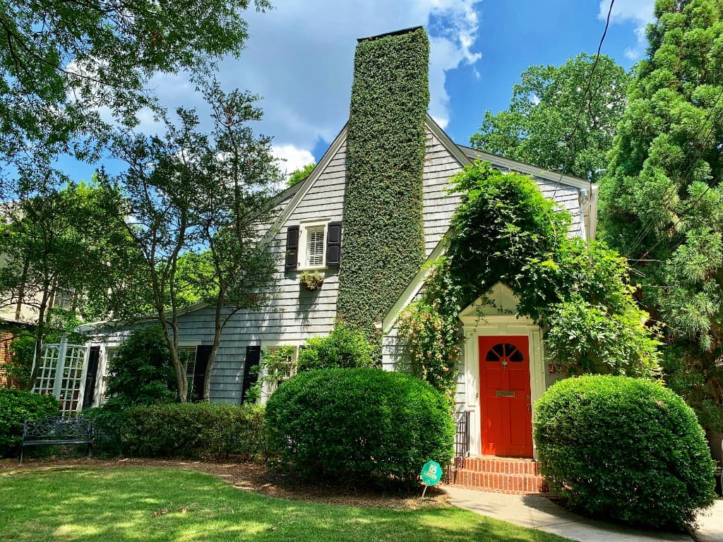 Charming home with a red front door and green lawn